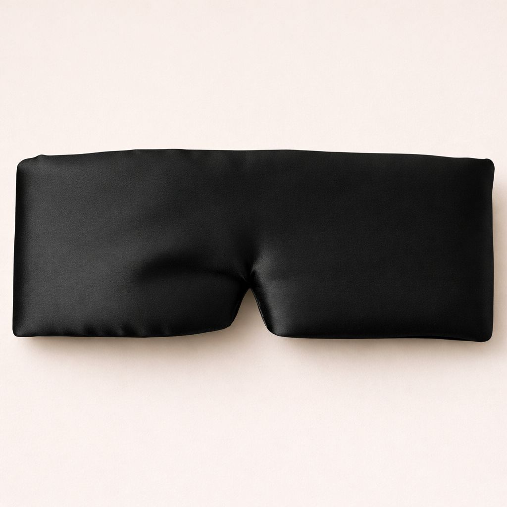 Black sleep mask on a light beige background